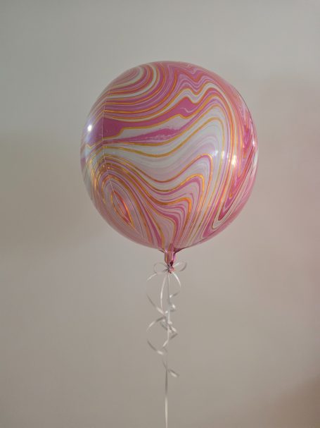 Rosa und weiß marmorierter Folienballon Rosa und weiße marmorierte Ballon schwebt an einem transparenten Band.