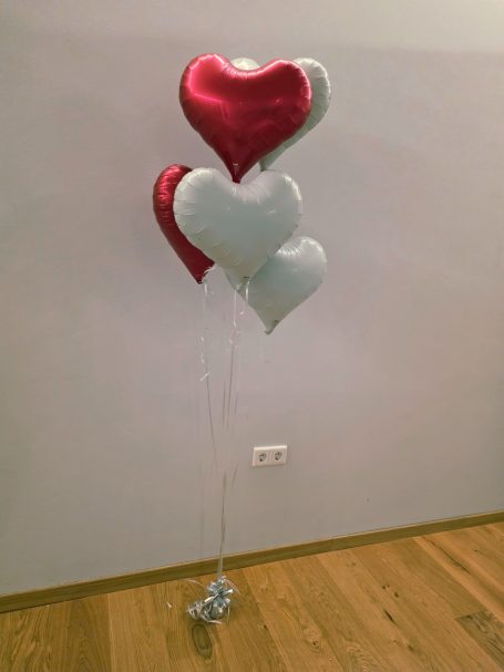 Herzförmige Luftballons in Rot und weiß inkl. Ballongewicht Drei herzförmige Luftballons in Rot und Silber, an Schnüren befestigt.